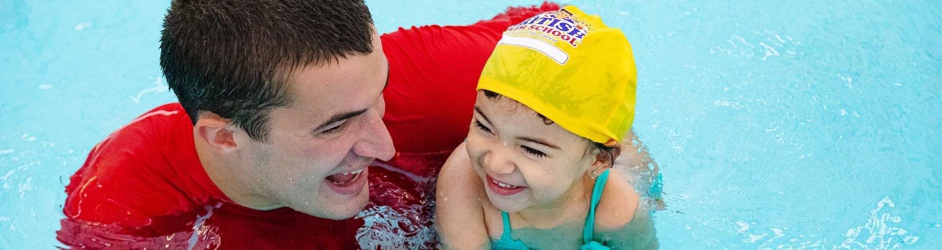 Swim instructor with child in swimming pool