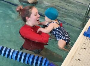 Dani helping a baby into the water