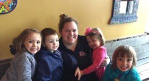 British Swim School Aquatics Director Courtney with four children smiling