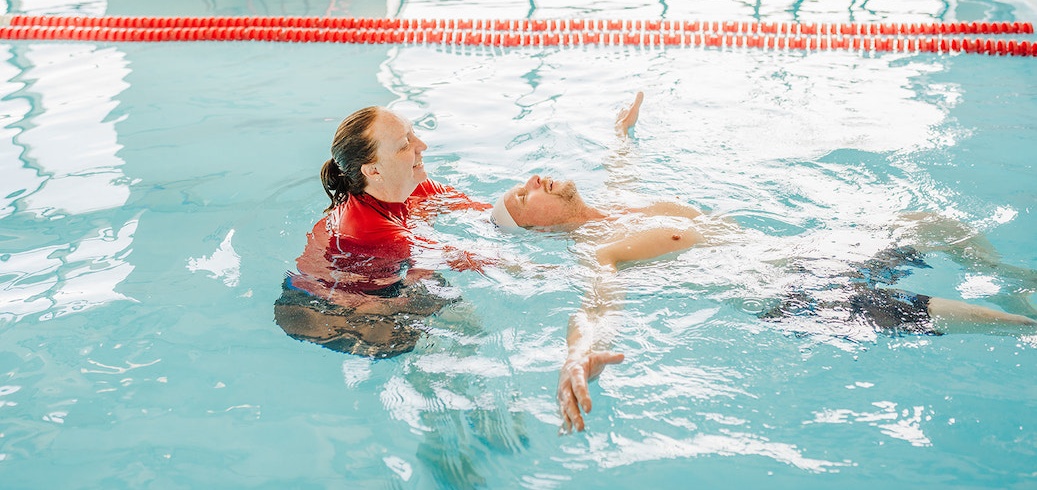 Swim instructor teaching a swimming class for adults
