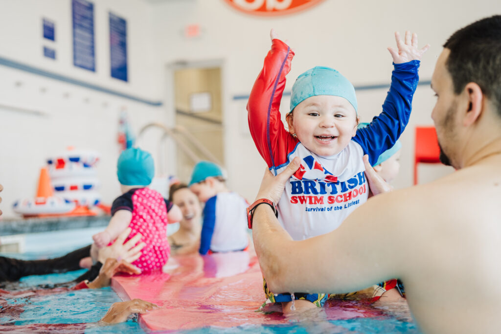 British Swim School instructors and parents teaching young swimmers during indoor swim lessons in Cypress TX