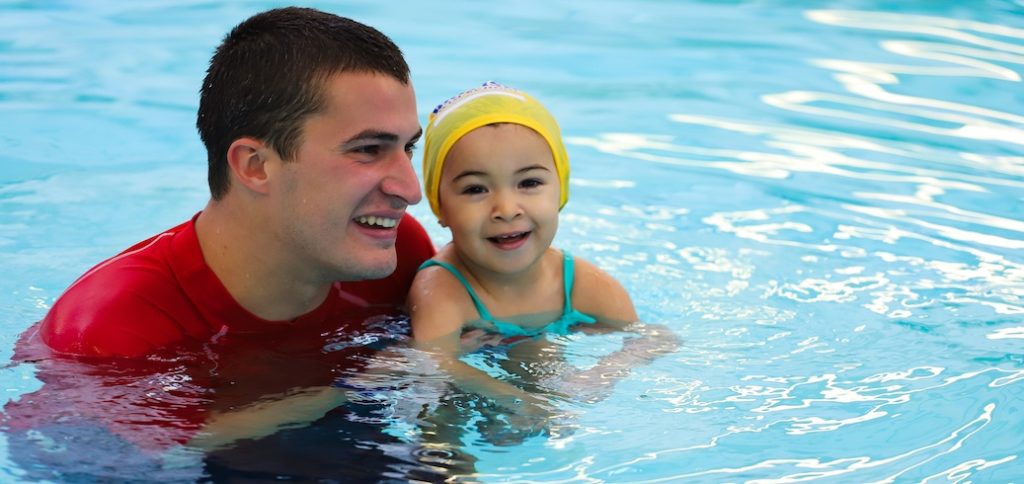 Swim instructor teaching a swimming lesson for kids