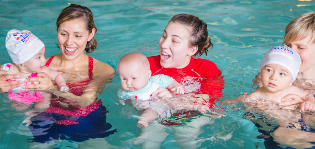 Swim instructor teaching an infant swim class