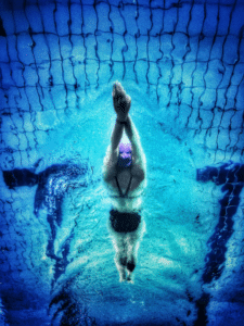 Woman swimming in pool lane in swim cap