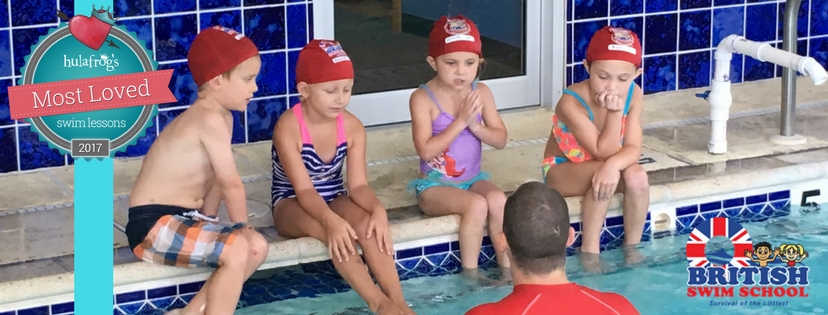 Children at swim lessons sitting along edge of pool