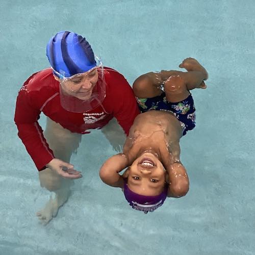 Swim Instructor teaching a child to float on their back
