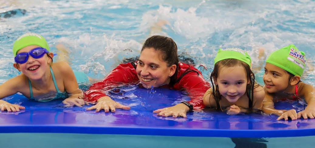 Swim Instructor teaching three children to swim