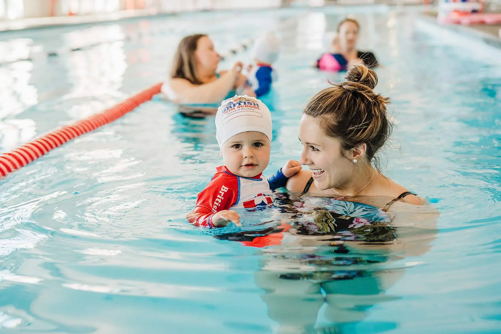 British Swim School instructor working with a young swimmer in the pool
