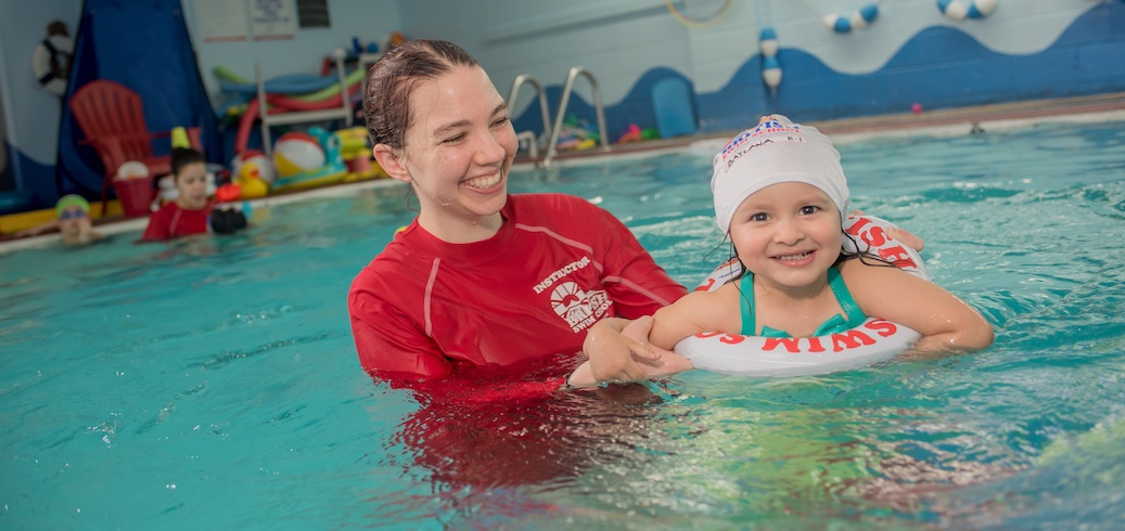 Swim instructor teaching a toddler swimming lesson