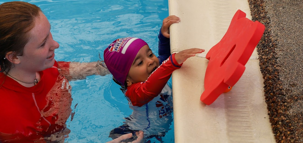 Swim Instructor teaching child swimming lessons