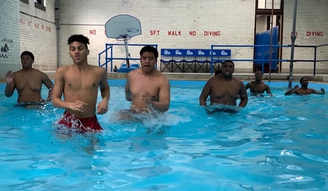 Lincoln High School football players doing pool workout