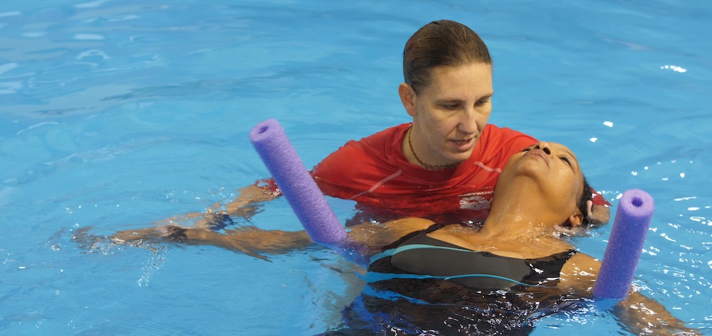 Instructor leading an adult swimming lesson
