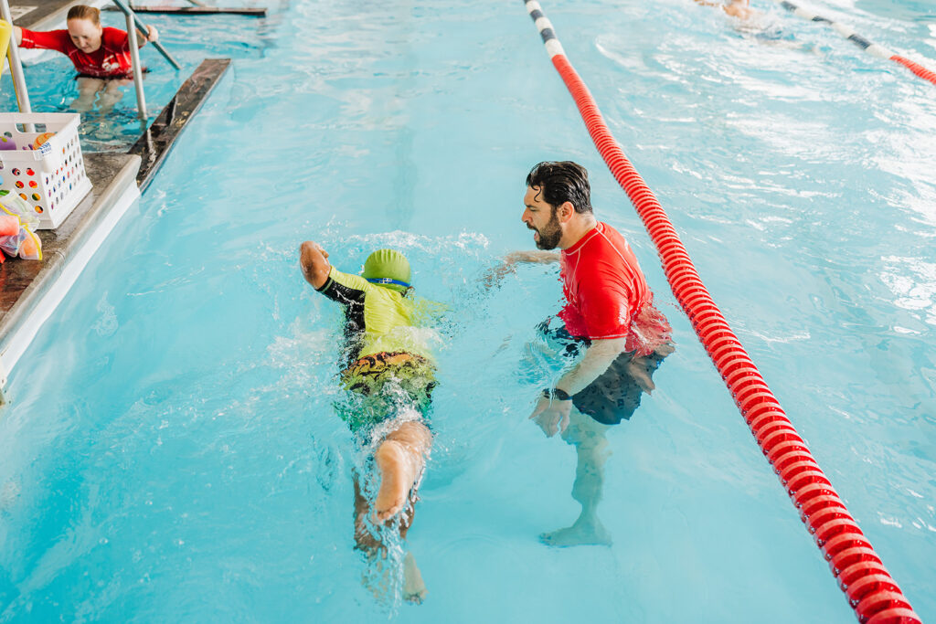 A swimmer being coached on by a certified British Swim School instructor during a year-round swimming lesson in Montgomery County.