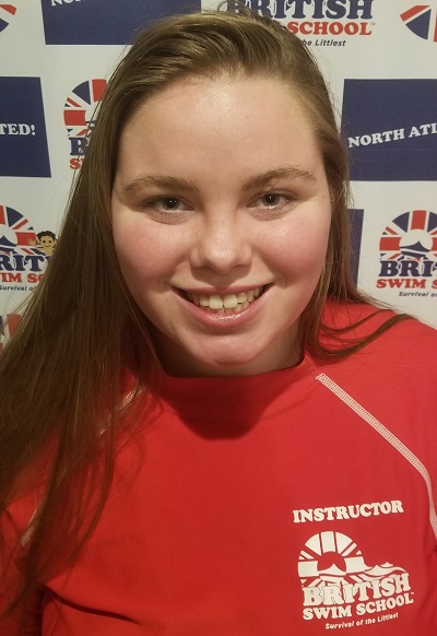 Brittany smiling in front of a British Swim School backdrop