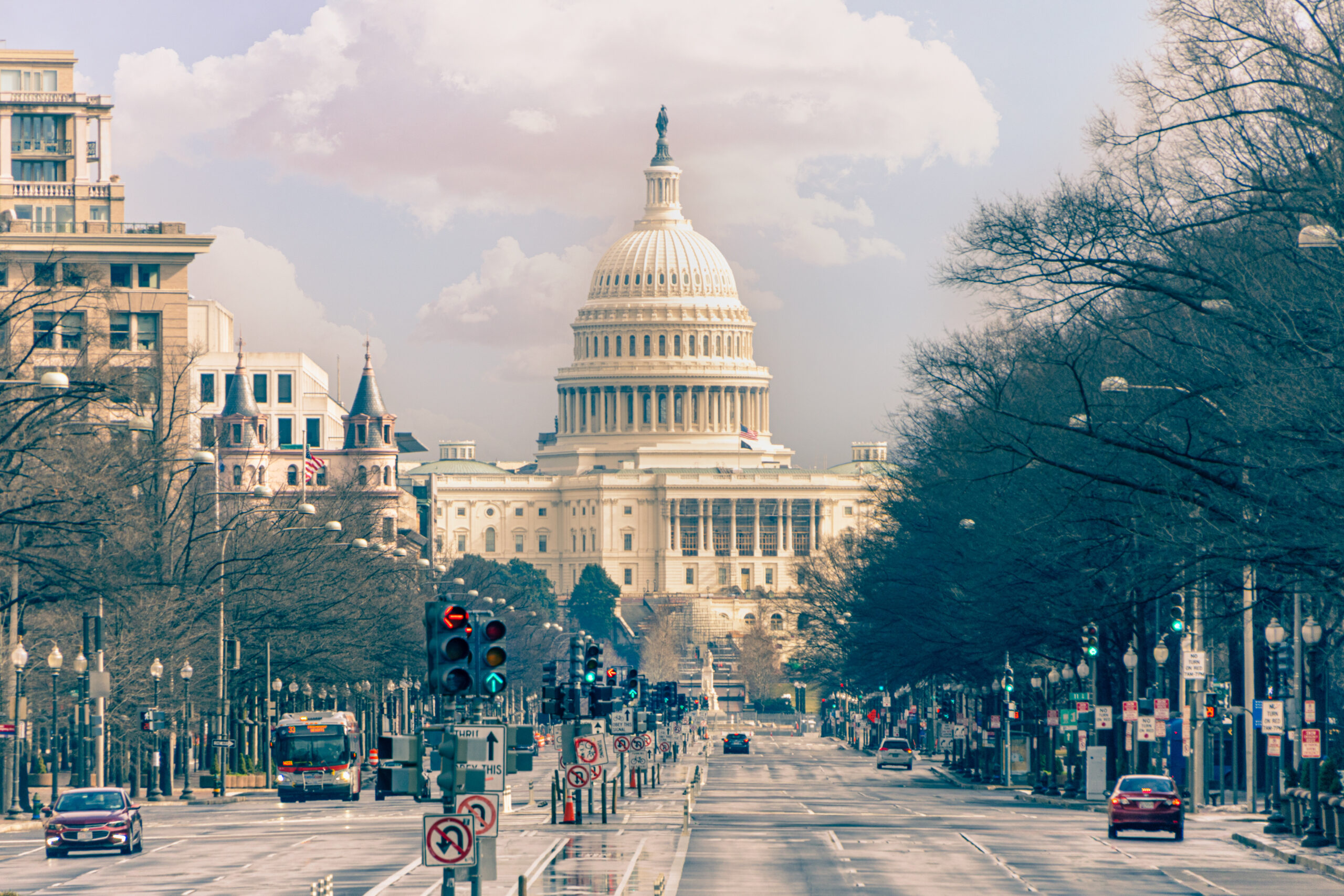 The majestic U.S. Capitol Building looms at the end of a wide city street with