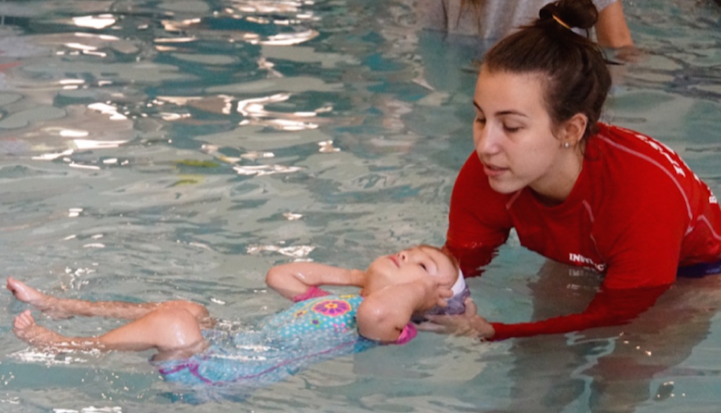 Instructor teaching an infant swimming lesson