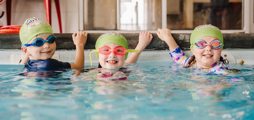 Children participating in an indoor swimming lesson