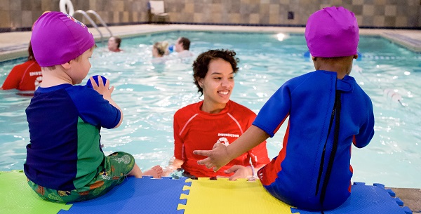 Swim students poolside for a lesson with a coach