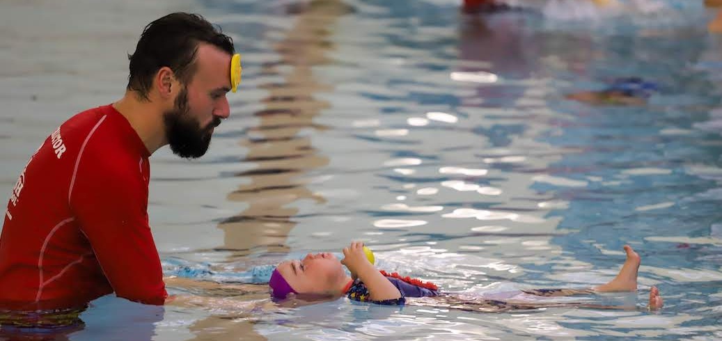 Swim Instructor teaching assisted back floating