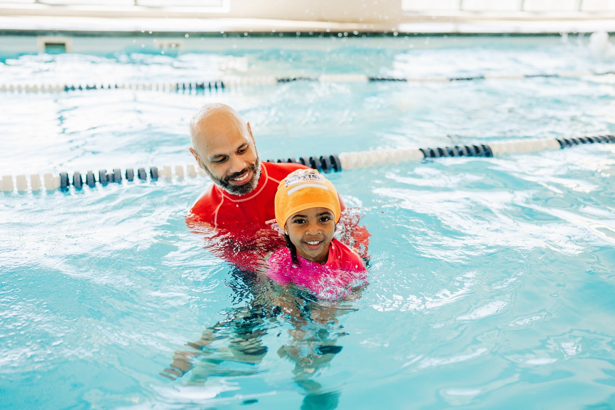 British Swim School instructor smiling with a young swimmer