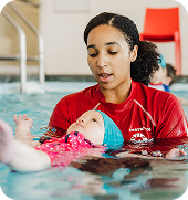 An instructor supporting a baby during a swim lesson