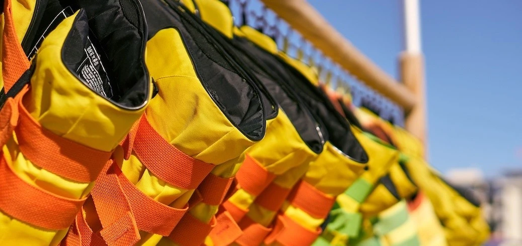 Children wearing properly fitted life jackets near the water