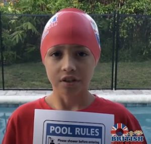 Young boy wearing a British Swim School swim cap