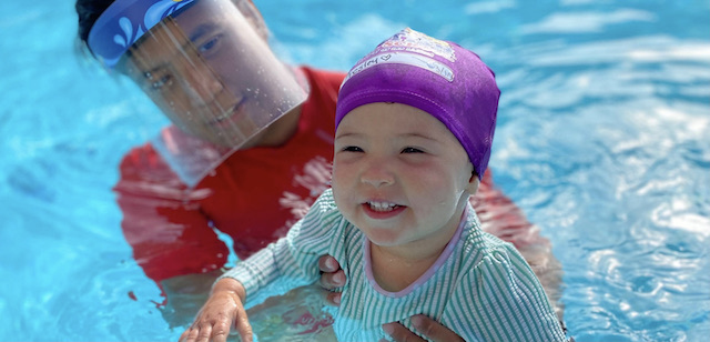 Instructor de natación en piscina que da clases de natación para niños pequeños