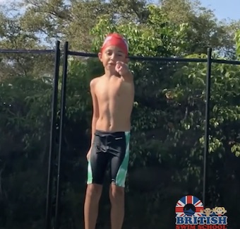 Young boy wearing a British Swim School swim cap